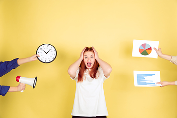 Image showing Caucasian young woman\'s portrait on yellow background, too much tasks