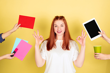 Image showing Caucasian young woman\'s portrait on yellow background, too much tasks