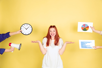 Image showing Caucasian young woman\'s portrait on yellow background, too much tasks