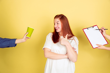 Image showing Caucasian young woman\'s portrait on yellow background, too much tasks