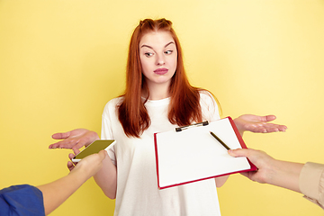 Image showing Caucasian young woman\'s portrait on yellow background, too much tasks