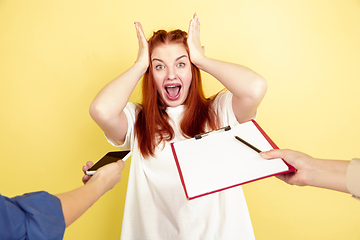 Image showing Caucasian young woman\'s portrait on yellow background, too much tasks