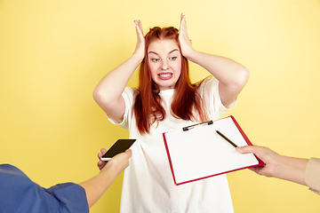 Image showing Caucasian young woman\'s portrait on yellow background, too much tasks