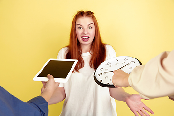 Image showing Caucasian young woman\'s portrait on yellow background, too much tasks