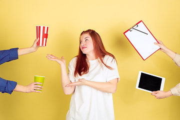 Image showing Caucasian young woman\'s portrait on yellow background, too much tasks