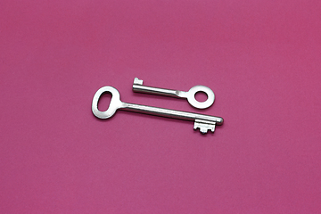 Image showing Metal keys close-up on bright crimson paper