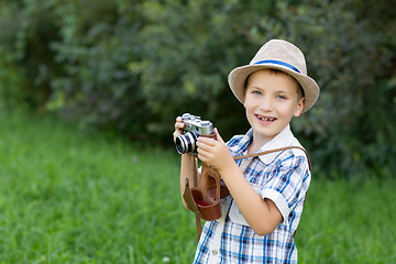 Image showing handsome little boy with retro camera outdoors