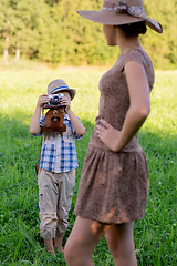 Image showing handsome little boy with retro camera and girl model