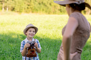 Image showing handsome little boy with retro camera and girl model