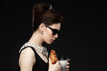 Image showing beautiful young woman in retro style with croissant