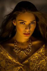 Image showing beautiful young woman with necklace in golden light