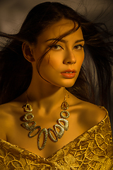 Image showing beautiful young woman with necklace in golden light