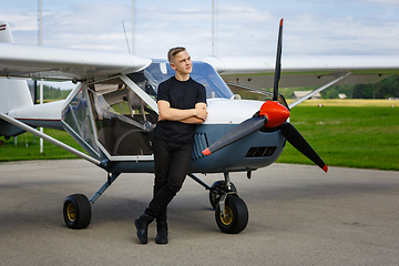 Image showing outdoor shot of young man in small plane cockpit