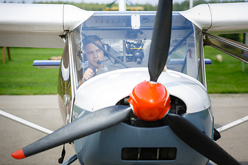 Image showing outdoor shot of young man in small plane cockpit