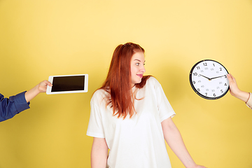 Image showing Caucasian young woman\'s portrait on yellow background, too much tasks