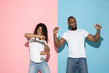 Image showing Young emotional man and woman on pink and blue background