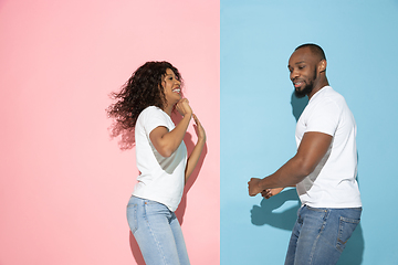 Image showing Young emotional man and woman on pink and blue background