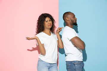 Image showing Young emotional man and woman on pink and blue background