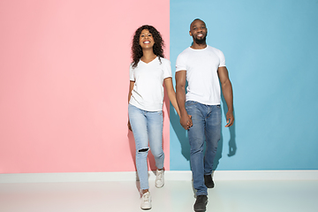 Image showing Young emotional man and woman on pink and blue background