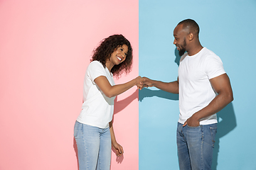 Image showing Young emotional man and woman on pink and blue background