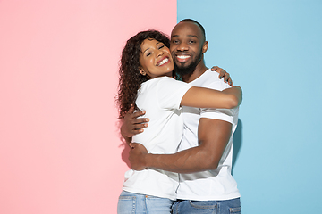 Image showing Young emotional man and woman on pink and blue background