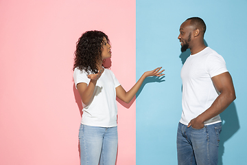 Image showing Young emotional man and woman on pink and blue background