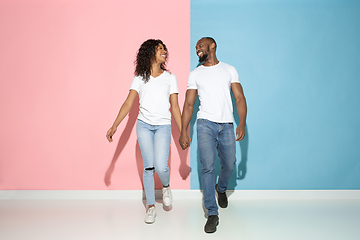 Image showing Young emotional man and woman on pink and blue background