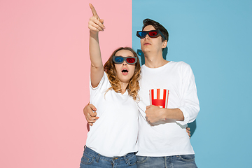 Image showing Young emotional man and woman on pink and blue background