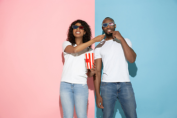 Image showing Young emotional man and woman on pink and blue background