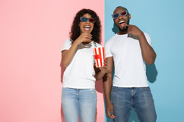 Image showing Young emotional man and woman on pink and blue background