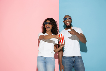 Image showing Young emotional man and woman on pink and blue background