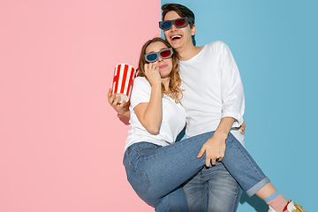 Image showing Young emotional man and woman on pink and blue background