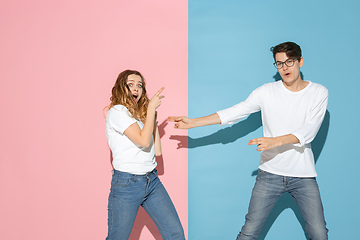 Image showing Young emotional man and woman on pink and blue background