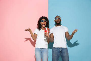 Image showing Young emotional man and woman on pink and blue background