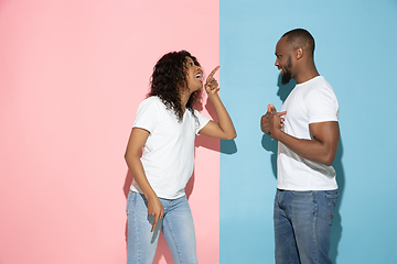 Image showing Young emotional man and woman on pink and blue background