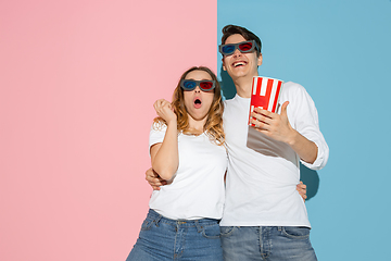 Image showing Young emotional man and woman on pink and blue background