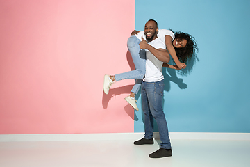 Image showing Young emotional man and woman on pink and blue background