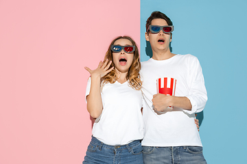 Image showing Young emotional man and woman on pink and blue background