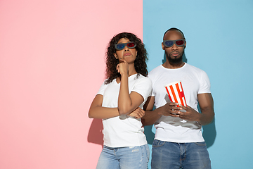 Image showing Young emotional man and woman on pink and blue background