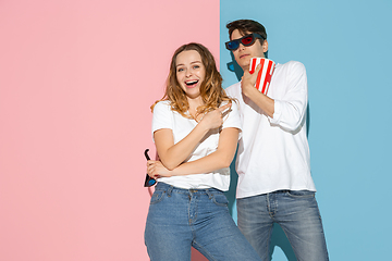 Image showing Young emotional man and woman on pink and blue background