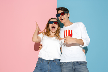 Image showing Young emotional man and woman on pink and blue background