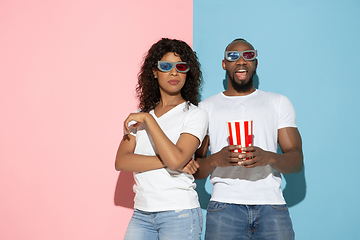 Image showing Young emotional man and woman on pink and blue background