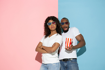 Image showing Young emotional man and woman on pink and blue background