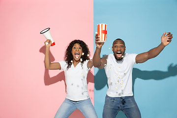 Image showing Young emotional man and woman on pink and blue background