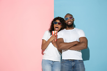 Image showing Young emotional man and woman on pink and blue background