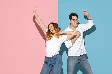 Image showing Young emotional man and woman on pink and blue background