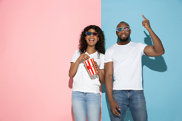 Image showing Young emotional man and woman on pink and blue background