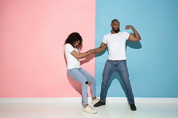 Image showing Young emotional man and woman on pink and blue background