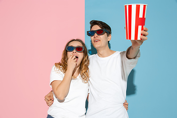 Image showing Young emotional man and woman on pink and blue background