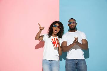 Image showing Young emotional man and woman on pink and blue background